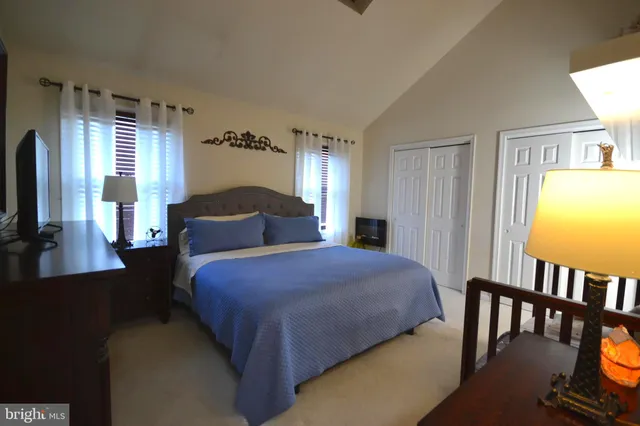a bedroom with a bed a dresser and a flat screen tv