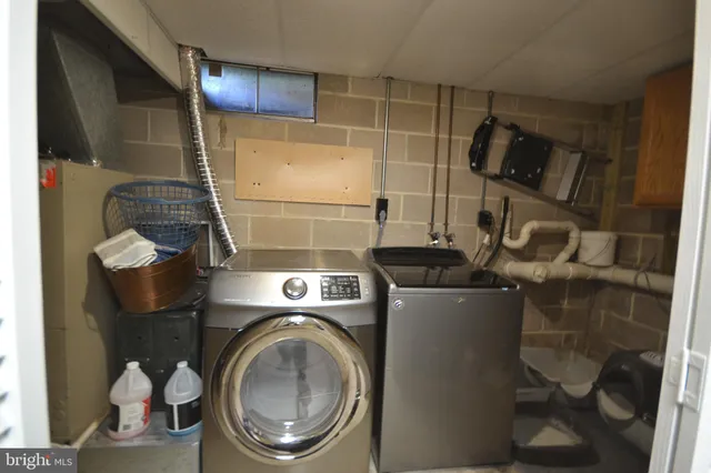a utility room with dryer washer and a view of living room