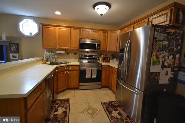 a kitchen with stainless steel appliances granite countertop a refrigerator a stove and a sink