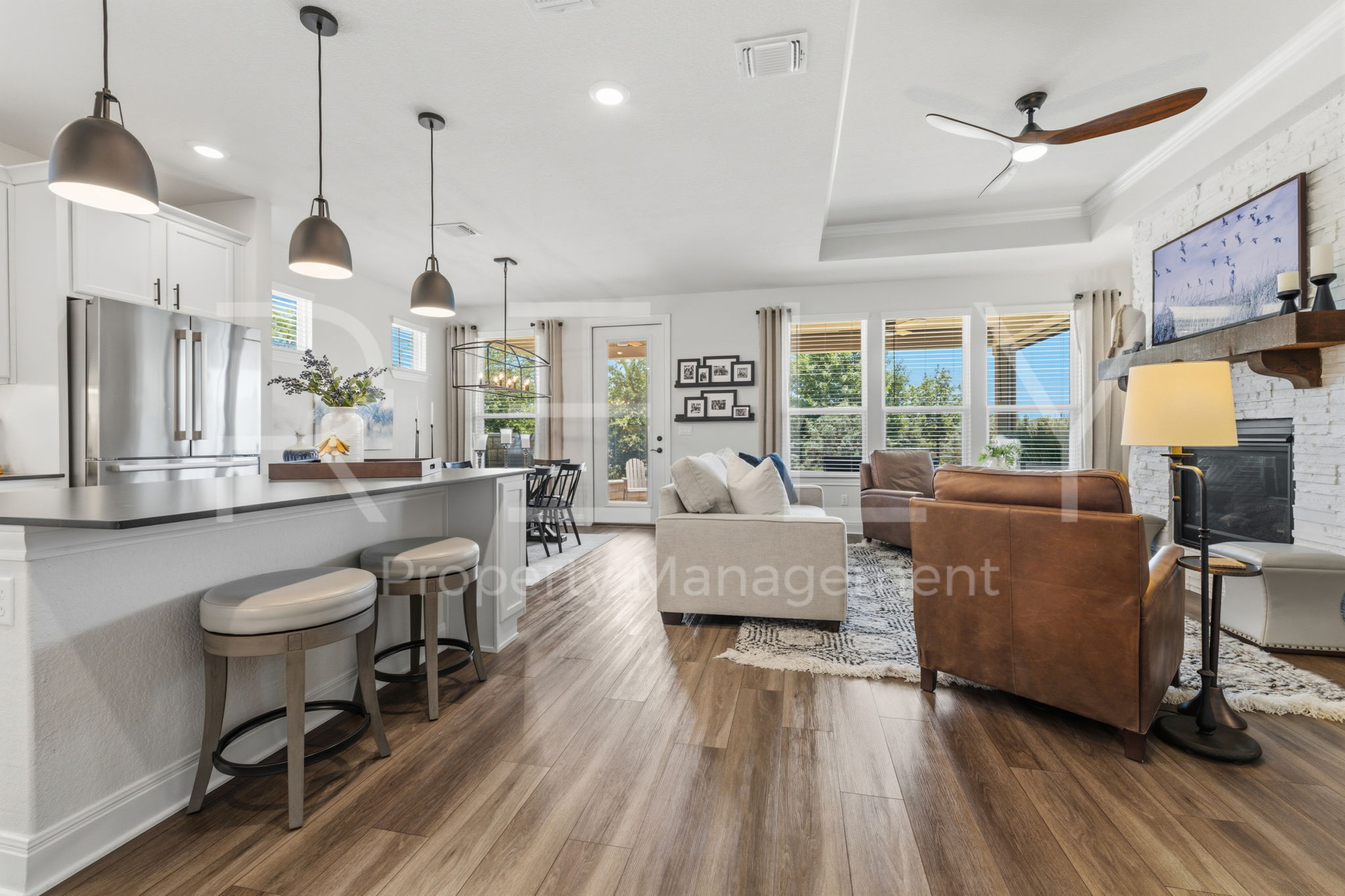 101 Spanish Star Street Georgetown, TX 78633 - Photo 10 of 39 An open concept living area boasts a modern kitchen island with pendant lighting and views of the verdant outdoors.