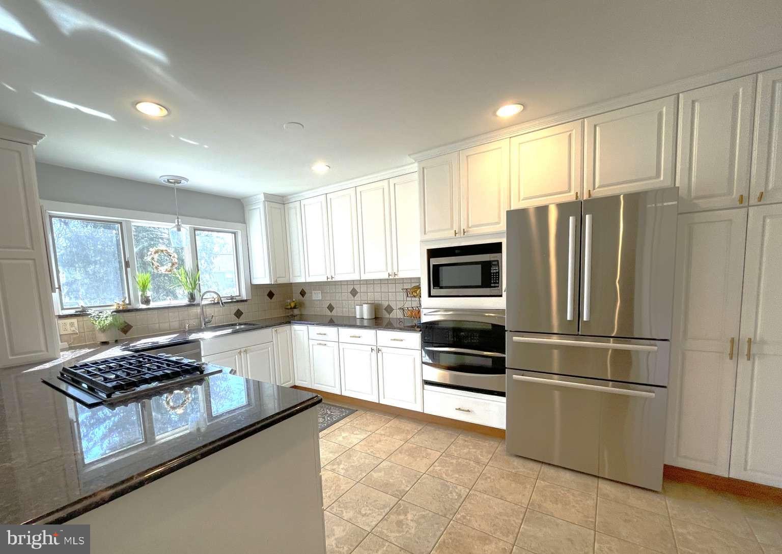 102 Danforth Place Wilmington, DE 19810 - Photo 3 of 21 a kitchen with stainless steel appliances kitchen island granite countertop a refrigerator and a stove top oven