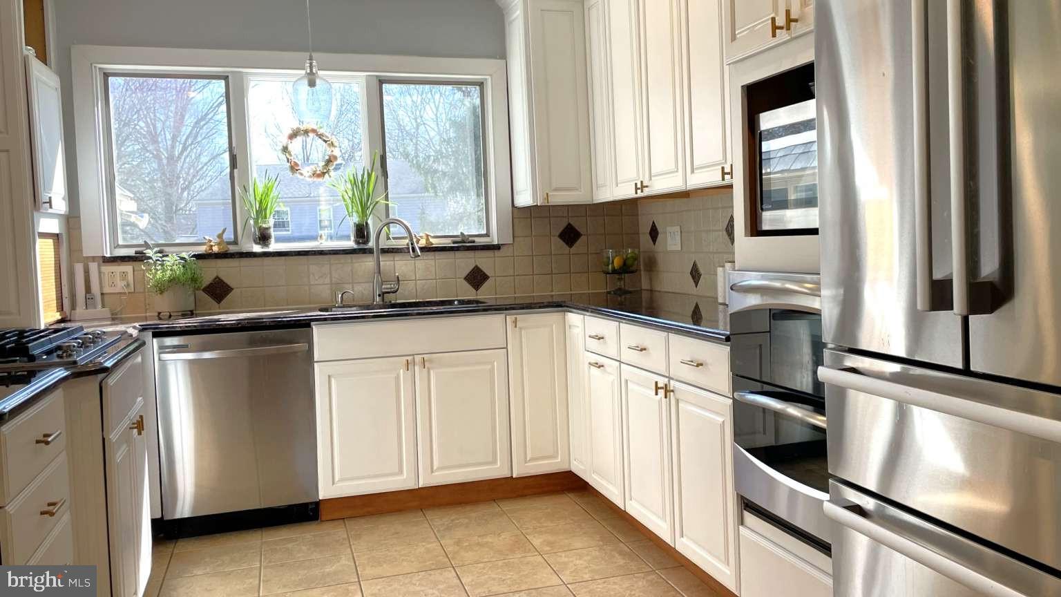 102 Danforth Place Wilmington, DE 19810 - Photo 4 of 21 a kitchen with granite countertop white cabinets and white appliances