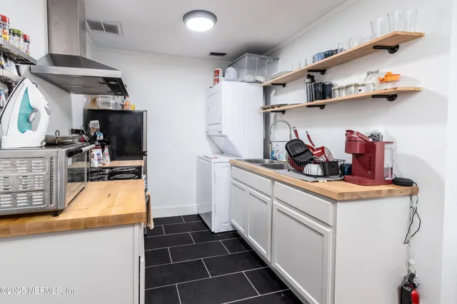 a kitchen with white cabinets and sink