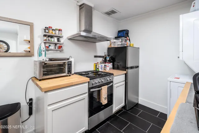 a kitchen with a stove and a chandelier