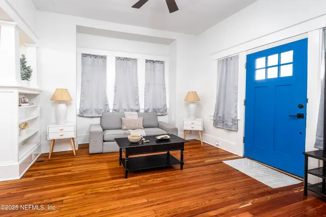 a living room with furniture and wooden floor