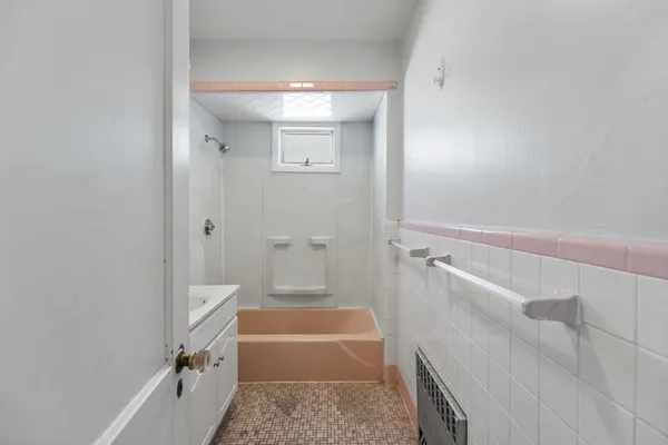 a bathroom with a tub a sink and a shower