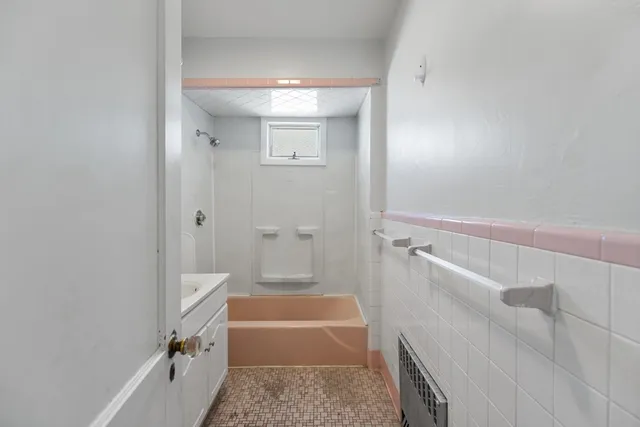 a bathroom with a tub a sink and a shower
