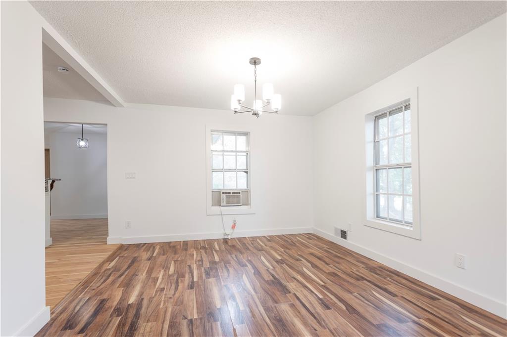 4361 Ben Hill Road Lithia Springs, GA 30122 - Photo 12 of 35 an empty room with wooden floor cabinet and windows