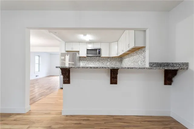 a kitchen with granite countertop a sink a counter top space and cabinets