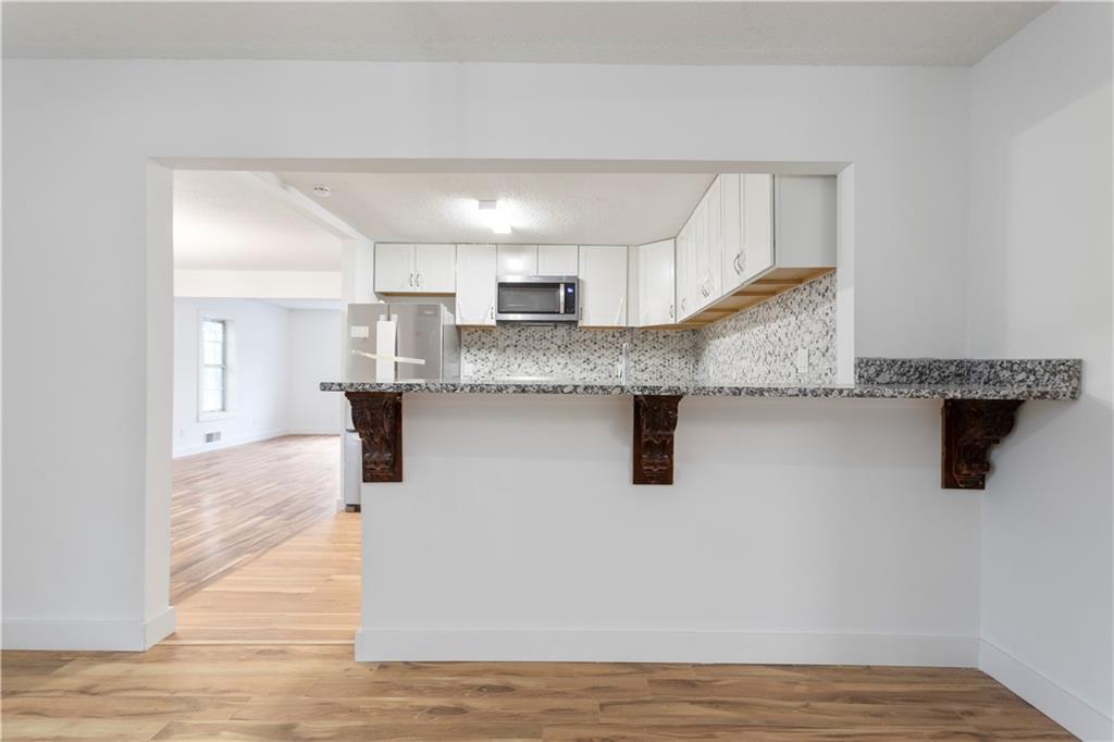 4361 Ben Hill Road Lithia Springs, GA 30122 - Photo 15 of 35 a kitchen with granite countertop a sink a counter top space and cabinets