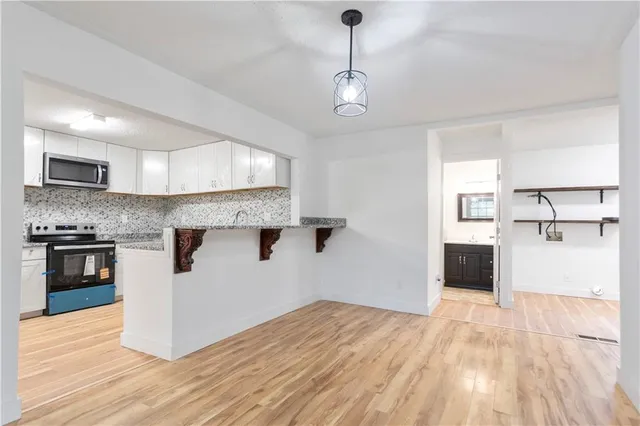 a kitchen with stainless steel appliances granite countertop a stove and cabinets