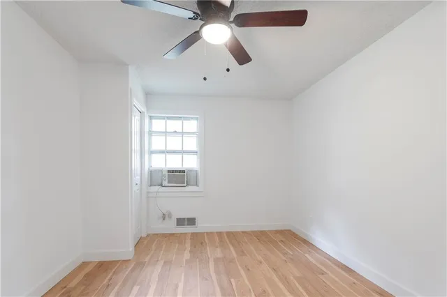an empty room with a window and wooden floor