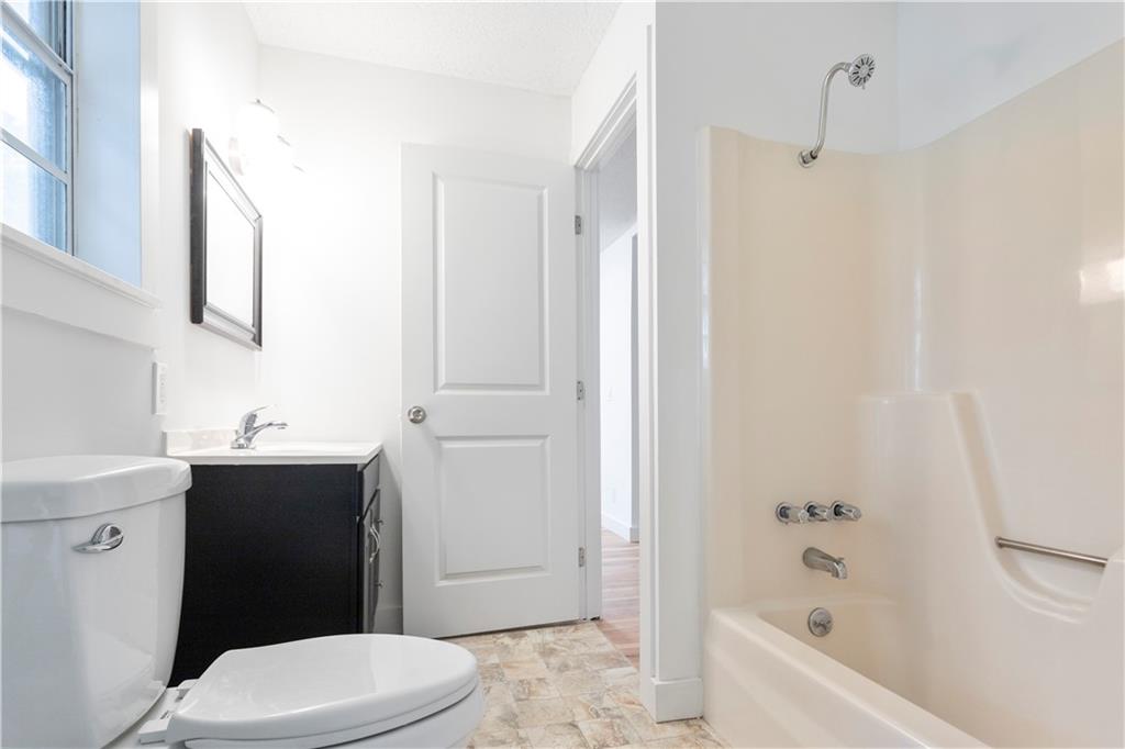 4361 Ben Hill Road Lithia Springs, GA 30122 - Photo 22 of 35 a bathroom with a sink a toilet and shower