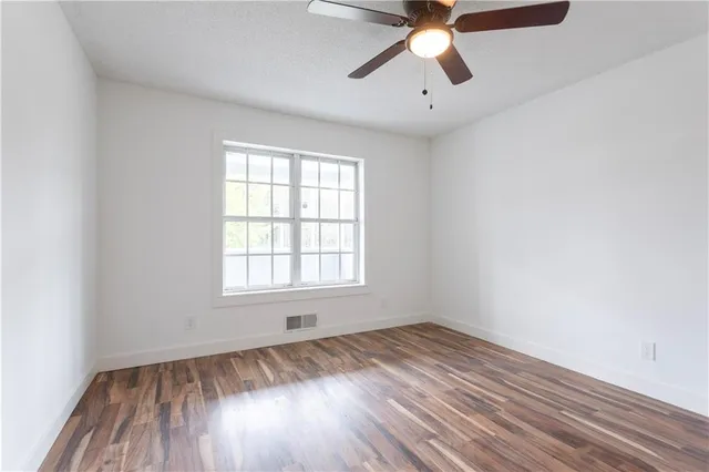 an empty room with a window and a ceiling fan
