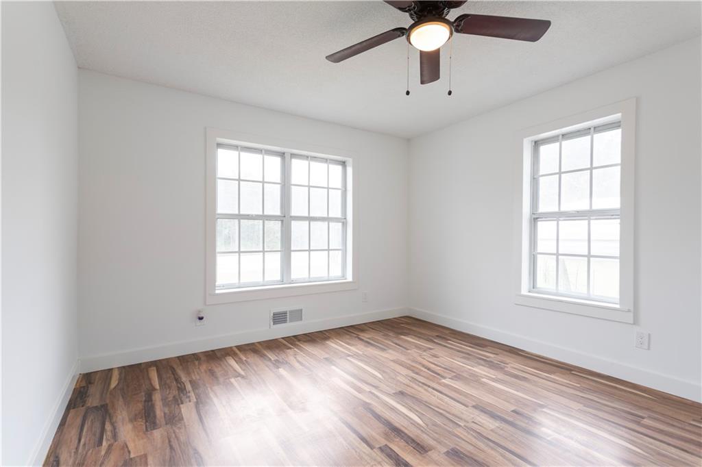 4361 Ben Hill Road Lithia Springs, GA 30122 - Photo 29 of 35 an empty room with chandelier fan and windows