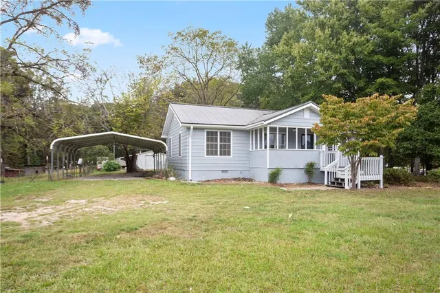 a front view of a house with a garden and trees