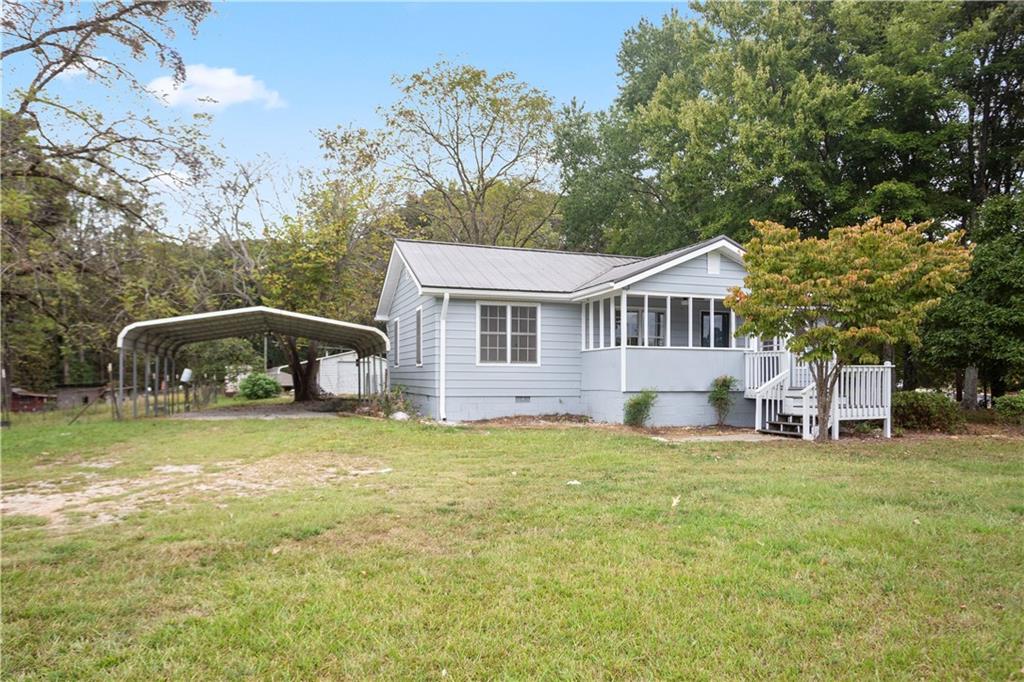 4361 Ben Hill Road Lithia Springs, GA 30122 - Photo 3 of 35 a front view of a house with a garden and trees