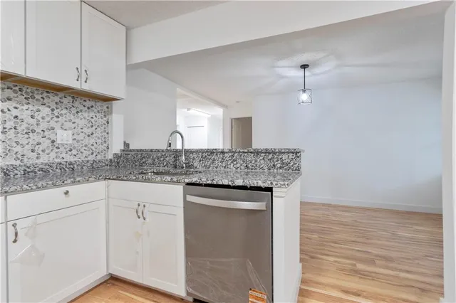 a kitchen with granite countertop a sink and cabinets