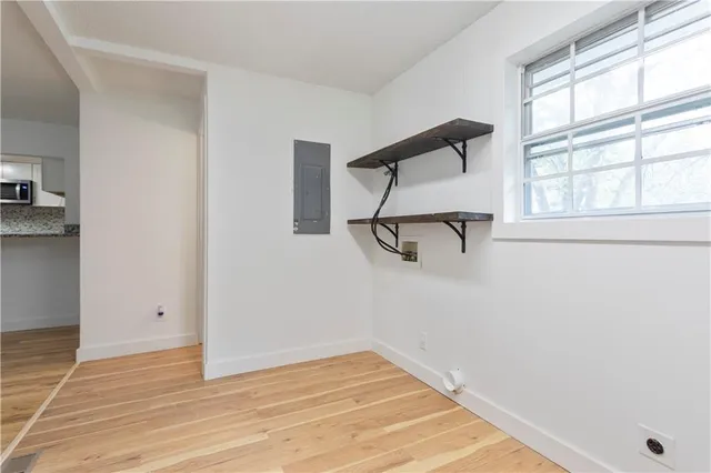 an empty room with a window and wooden floor