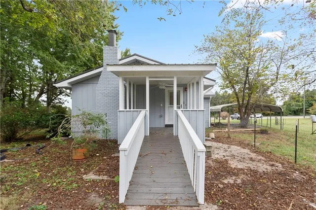a view of a house with backyard and trees