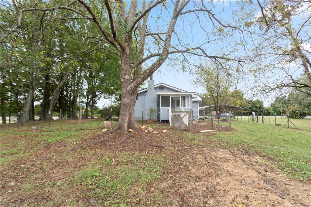 4361 Ben Hill Road Lithia Springs, GA 30122 - Photo 6 of 35 a view of a yard with a house and a tree