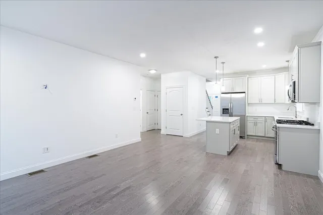 a view of kitchen with a sink a refrigerator and wooden floor