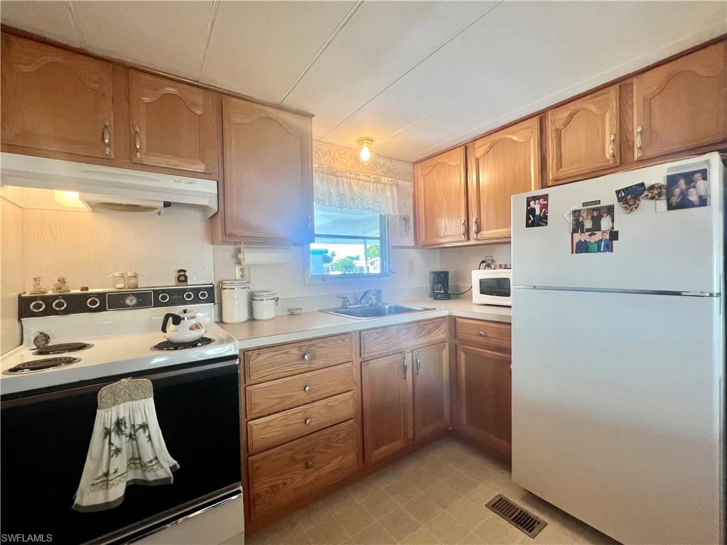 112 Cape Sable Drive Naples, FL 34104 - Photo 13 of 25 a kitchen with a sink a stove and a refrigerator