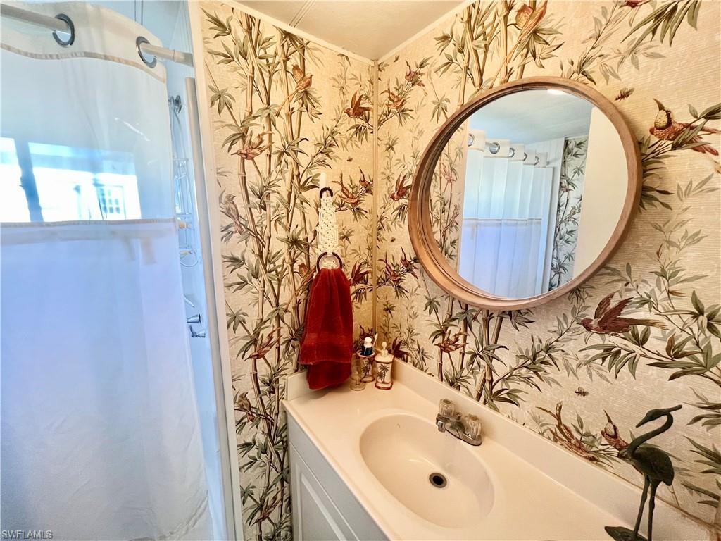 112 Cape Sable Drive Naples, FL 34104 - Photo 6 of 25 a bathroom with a sink and a mirror