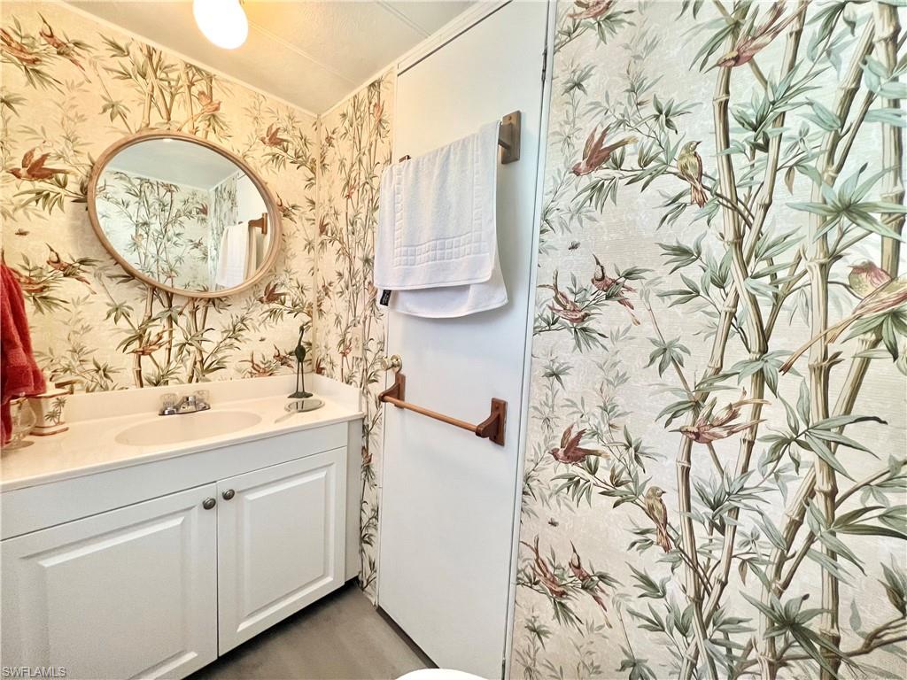 112 Cape Sable Drive Naples, FL 34104 - Photo 7 of 25 a bathroom with a sink and a mirror
