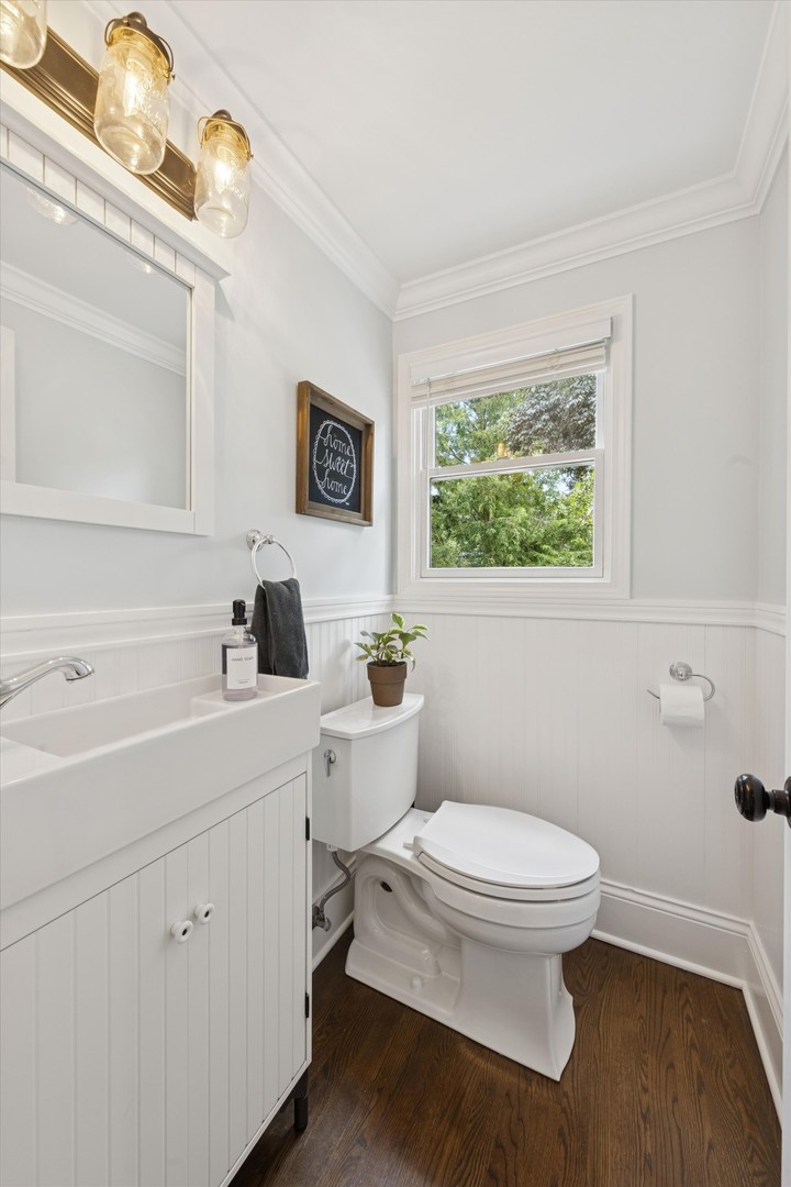 561 North County Line Road Hinsdale, IL 60521 - Photo 9 of 30 a bathroom with a toilet a sink a mirror and a window