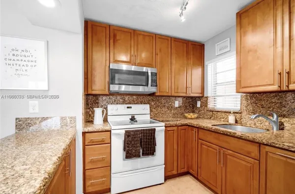 a kitchen with stainless steel appliances granite countertop a sink stove and microwave