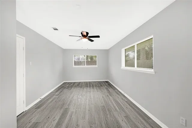 an empty room with a window and wooden floor