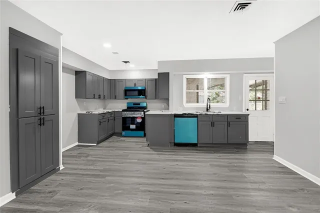 a view of kitchen with granite countertop stainless steel appliances cabinets a sink and a window
