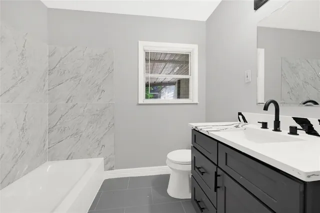 a bathroom with a sink toilet vanity and bathtub