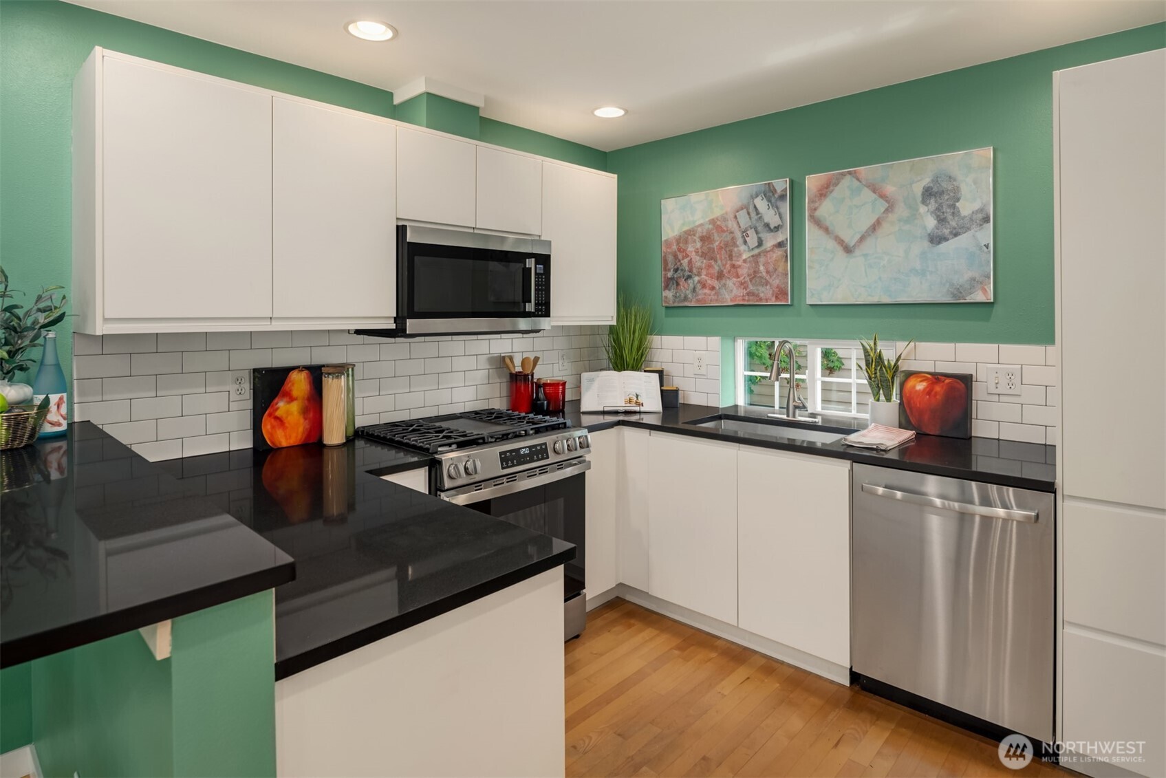 3302 West Government Way, Unit A Seattle, WA 98199 - Photo 14 of 32 a kitchen with stainless steel appliances granite countertop a stove a sink and a microwave