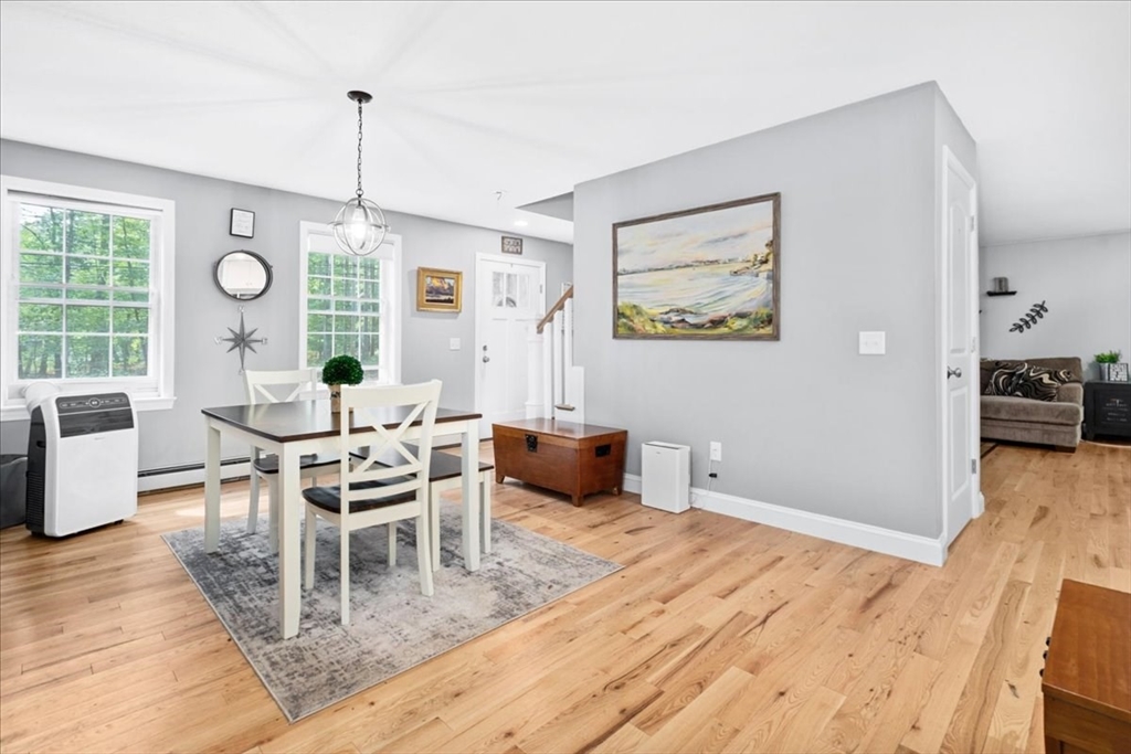 61 Blake Road Epping, NH 03042 - Photo 18 of 41 a dining room with furniture a chandelier and wooden floor