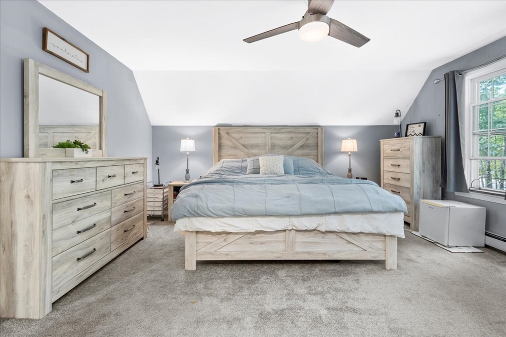 61 Blake Road Epping, NH 03042 - Photo 23 of 41 a bedroom with a large bed and a mirror on dresser