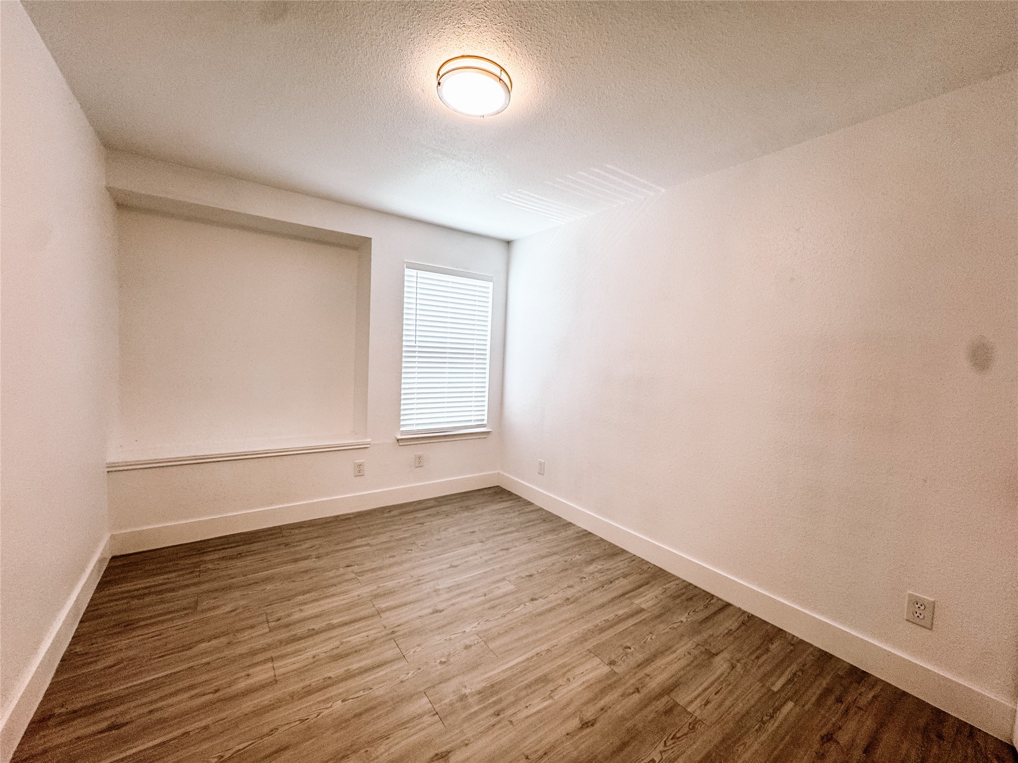12524 Pebblestone Street Houston, TX 77072 - Photo 13 of 16 an empty room with wooden floor and windows