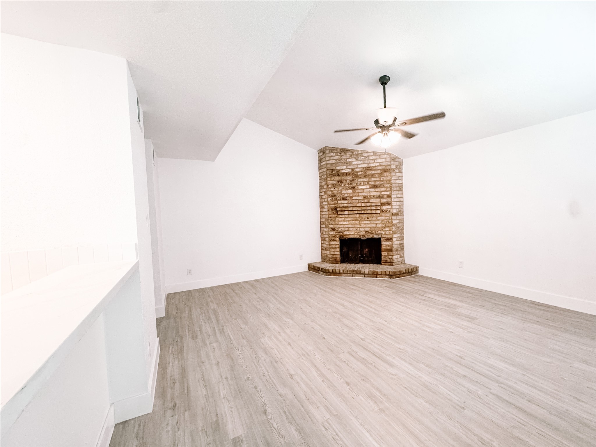 12524 Pebblestone Street Houston, TX 77072 - Photo 4 of 16 an empty room with a fireplace and wooden floor