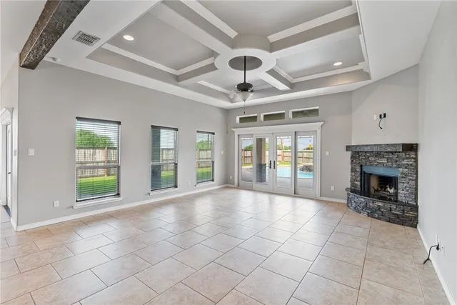 a view of an empty room with a fireplace and a window