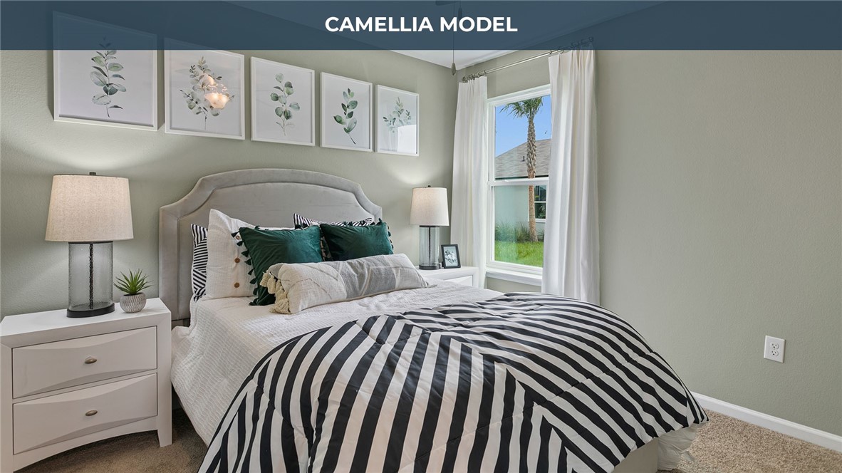 65760 Edgewater Drive Yulee, FL 32097 - Photo 11 of 35 a bedroom with a bed and a lamp on dresser