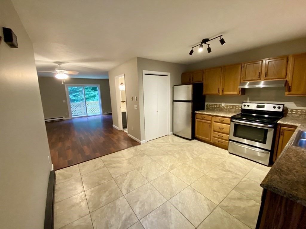 13 May Brook Road, Unit 13 Holland, MA 01521 - Photo 4 of 36 a kitchen with granite countertop a refrigerator and a stove top oven