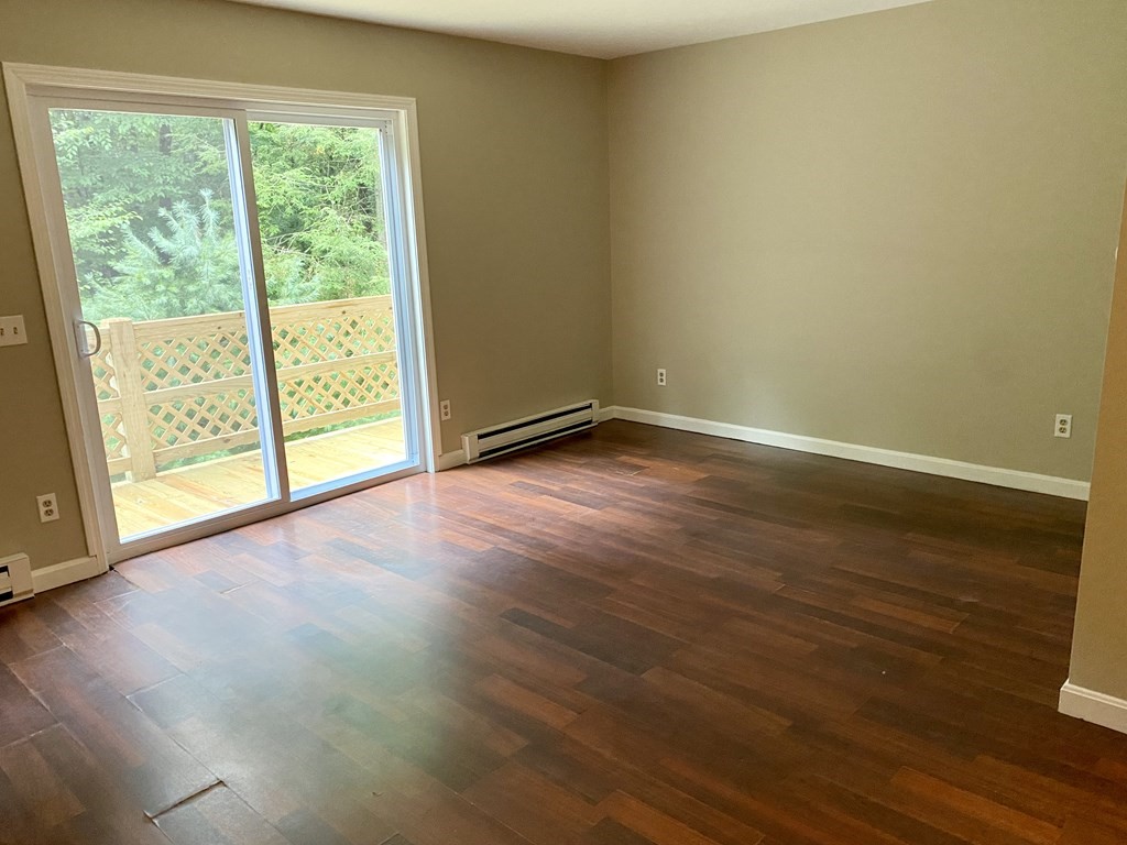 13 May Brook Road, Unit 13 Holland, MA 01521 - Photo 8 of 36 a view of an empty room with wooden floor and a window