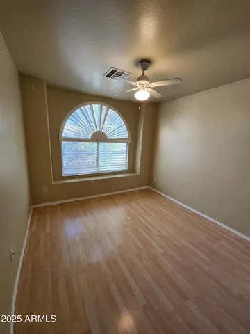 an empty room with windows and fan