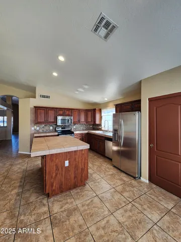 a kitchen with stainless steel appliances granite countertop a refrigerator and a stove