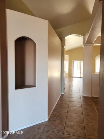 a view of a hallway with wooden floor and a bathroom