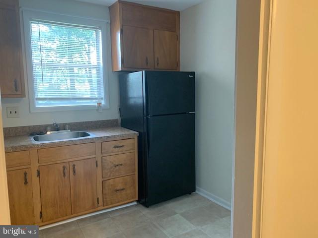 903 Cooks Lane, Unit 3A Baltimore, MD 21229 - Photo 4 of 6 a kitchen with a refrigerator sink and cabinets