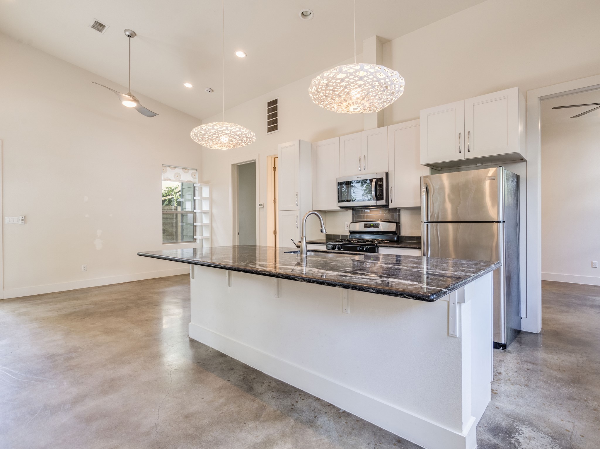 1404 Singleton Avenue, Unit B Austin, TX 78702 - Photo 3 of 21 A well-appointed kitchen island with striking stone counters provides ample space for culinary endeavors.