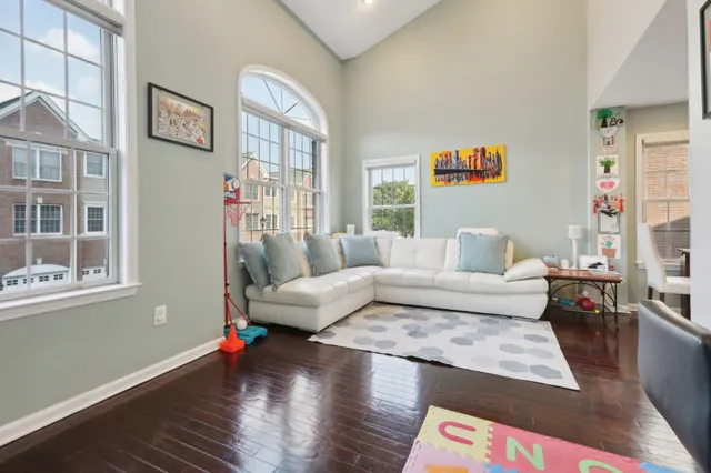 a living room with furniture wooden floor and a large window