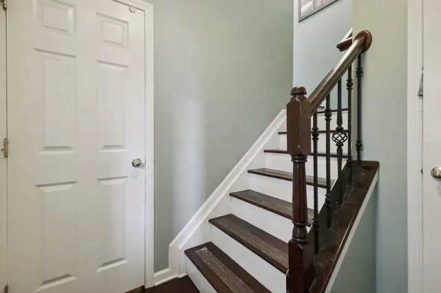 a living room with couches and kitchen view with wooden floor